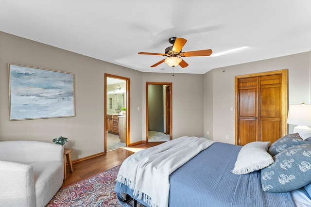 bedroom featuring connected bathroom, ceiling fan, baseboards, and wood finished floors