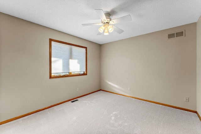 unfurnished room featuring visible vents, light carpet, a textured ceiling, and baseboards