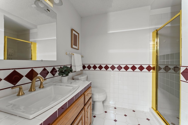 bathroom with a shower stall, a textured ceiling, tile walls, and toilet