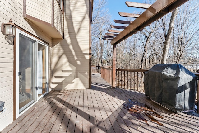 wooden deck with area for grilling and a pergola