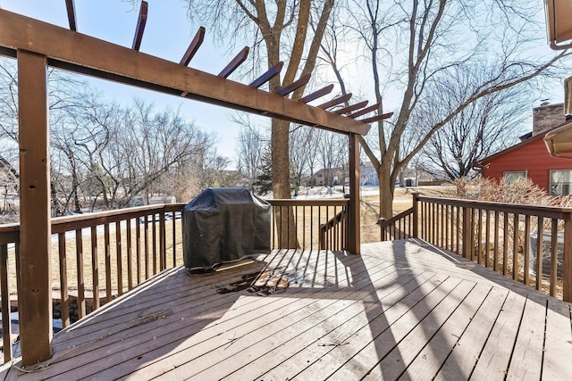 deck featuring a grill and a pergola