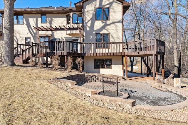 rear view of property featuring a wooden deck, a patio, stairs, and a pergola