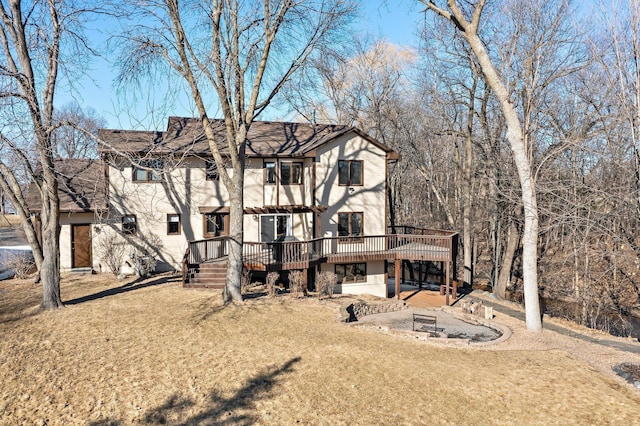 view of front facade featuring a deck, a front yard, and a patio area