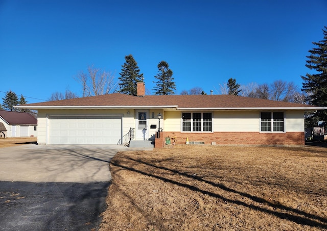 ranch-style home with a garage, driveway, and a chimney