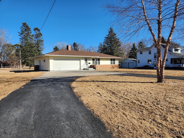 view of front of property with a garage, an outdoor structure, and a chimney