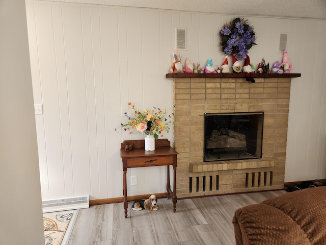 living area with visible vents, a fireplace, and wood finished floors