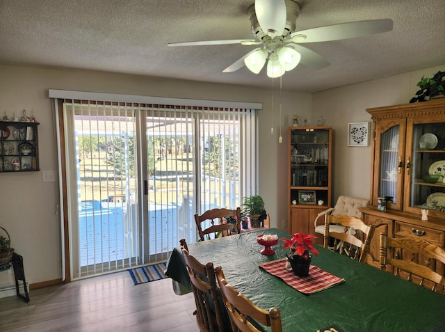 dining area with ceiling fan, a textured ceiling, and wood finished floors