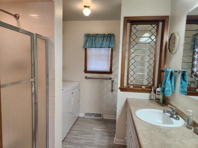 bathroom with vanity, visible vents, baseboards, independent washer and dryer, and a shower stall