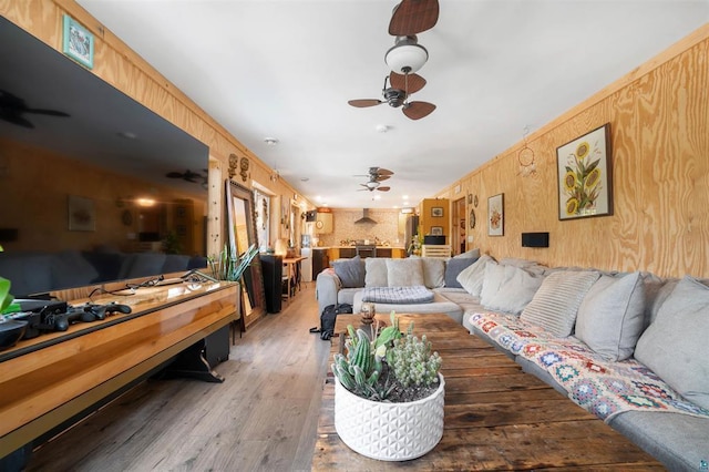 living area with a ceiling fan and wood finished floors