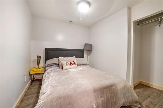 bedroom featuring a ceiling fan, baseboards, and wood finished floors