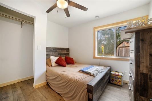 bedroom featuring a ceiling fan, baseboards, and wood finished floors