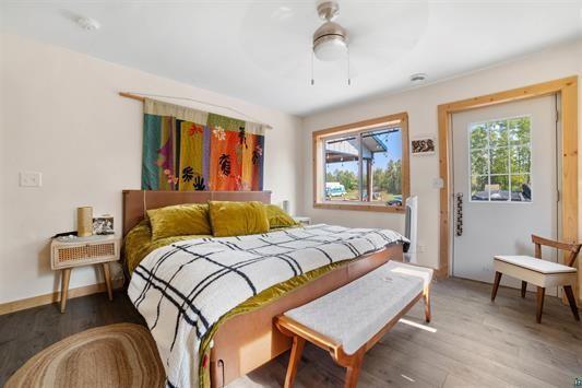 bedroom with ceiling fan, wood finished floors, and baseboards