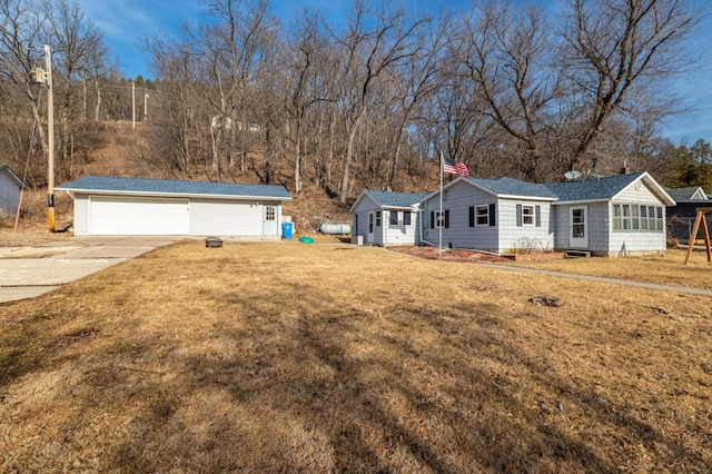 view of front of house featuring a front lawn, a garage, and an outdoor structure