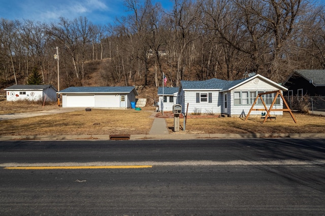 view of front of property with a garage and an outbuilding