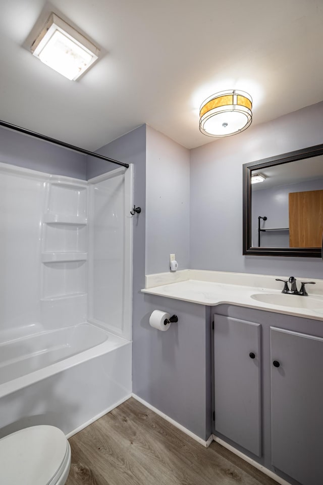 full bath with vanity, toilet, wood finished floors, and shower / bath combination