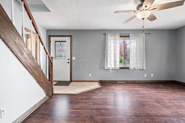 foyer entrance with stairway, a textured ceiling, wood finished floors, and a ceiling fan