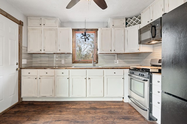 kitchen with black appliances, ceiling fan, decorative backsplash, white cabinetry, and a sink