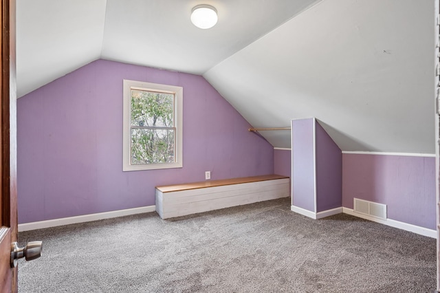 additional living space featuring vaulted ceiling, carpet, visible vents, and baseboards