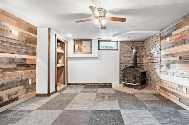 basement with wood walls and a wood stove