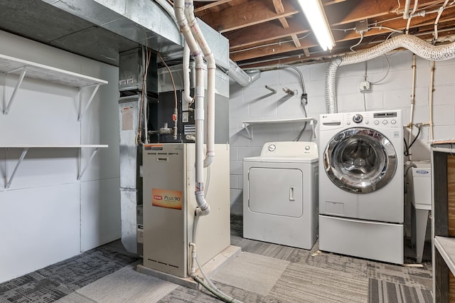 laundry room with heating unit, laundry area, and separate washer and dryer