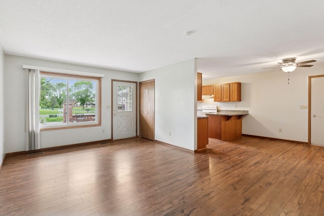 125 96th Ln NE, Blaine, MN 55434 - unfurnished living room featuring wood finished floors, baseboards, and a ceiling fan