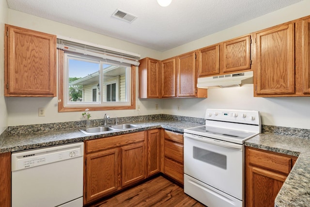 125 96th Ln NE, Blaine, MN 55434 - kitchen with white appliances, under cabinet range hood, a sink, dark wood finished floors, and dark countertops