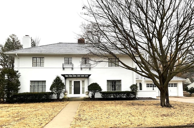 view of front of house featuring stucco siding and a chimney