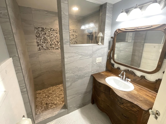 full bathroom with a walk in shower, tile walls, and vanity