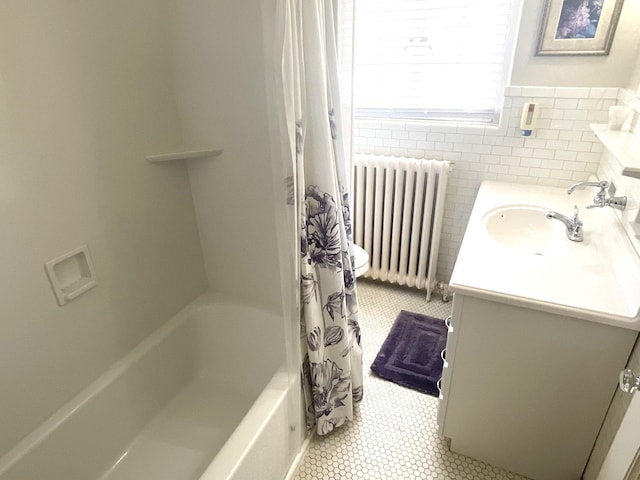 bathroom featuring tile patterned floors, radiator, tile walls, shower / bath combination with curtain, and vanity