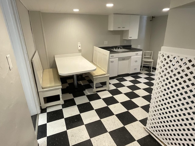 kitchen with tile patterned floors, recessed lighting, white cabinetry, and a sink