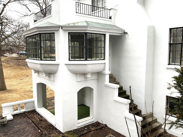 property entrance featuring a balcony and stucco siding