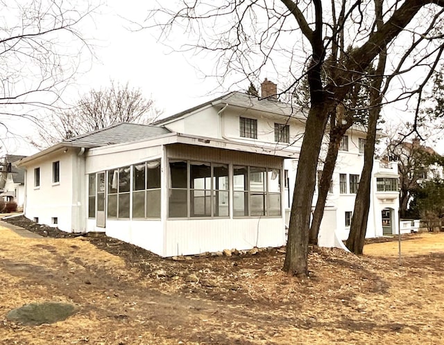 exterior space with a chimney and a sunroom