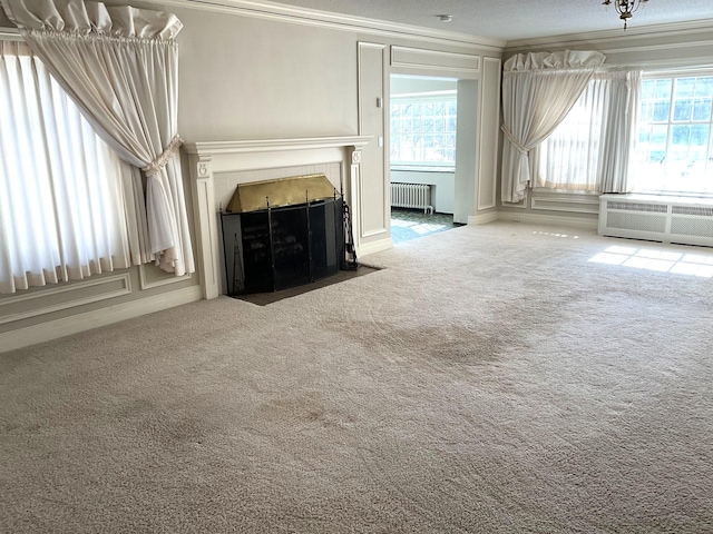 401 5th Ave SW, Austin, MN 55912 - unfurnished living room featuring a fireplace with flush hearth, radiator, carpet, and crown molding