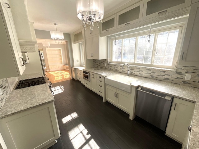 401 5th Ave SW, Austin, MN 55912 - kitchen featuring stainless steel dishwasher, a sink, backsplash, a notable chandelier, and dark wood-style floors