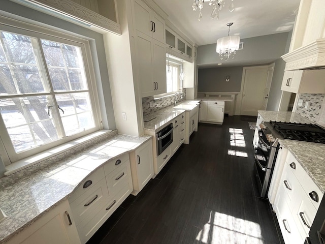 401 5th Ave SW, Austin, MN 55912 - kitchen with a sink, glass insert cabinets, appliances with stainless steel finishes, white cabinetry, and a notable chandelier