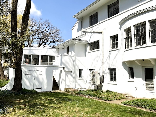 401 5th Ave SW, Austin, MN 55912 - exterior space featuring stucco siding, stairway, ac unit, and a lawn