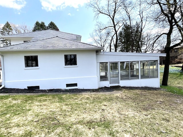 401 5th Ave SW, Austin, MN 55912 - rear view of house with a lawn, a sunroom, and stucco siding