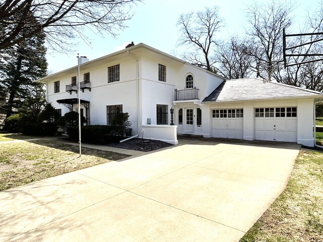 401 5th Ave SW, Austin, MN 55912 - exterior space with concrete driveway, an attached garage, a balcony, and stucco siding
