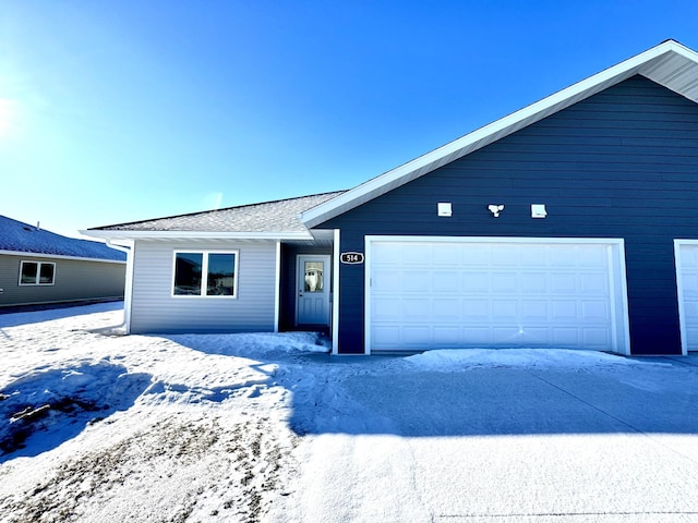 view of front of home featuring a garage and a shingled roof