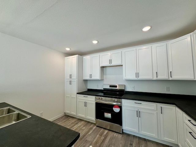 kitchen featuring electric stove, dark countertops, and wood finished floors