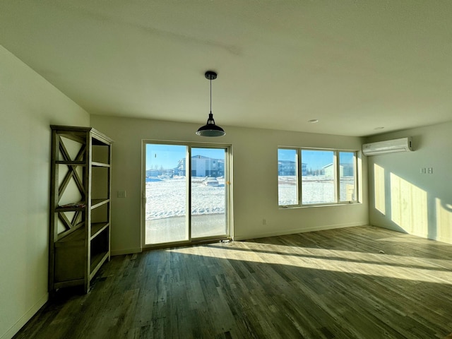 interior space featuring a wall mounted AC, dark wood finished floors, and baseboards