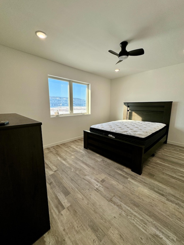 bedroom featuring a ceiling fan, baseboards, wood finished floors, and recessed lighting