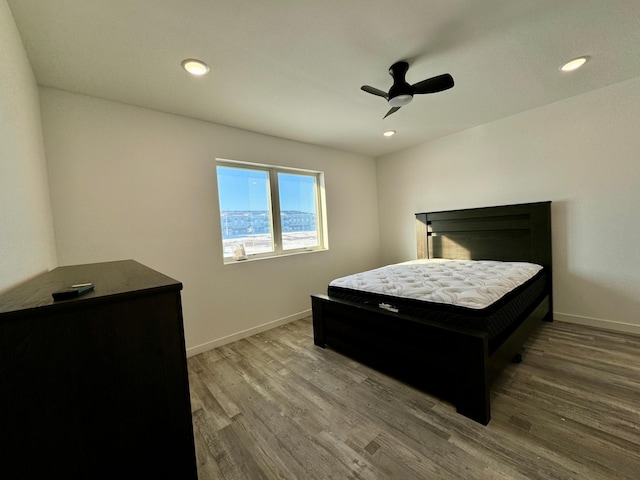 bedroom with recessed lighting, wood finished floors, a ceiling fan, and baseboards