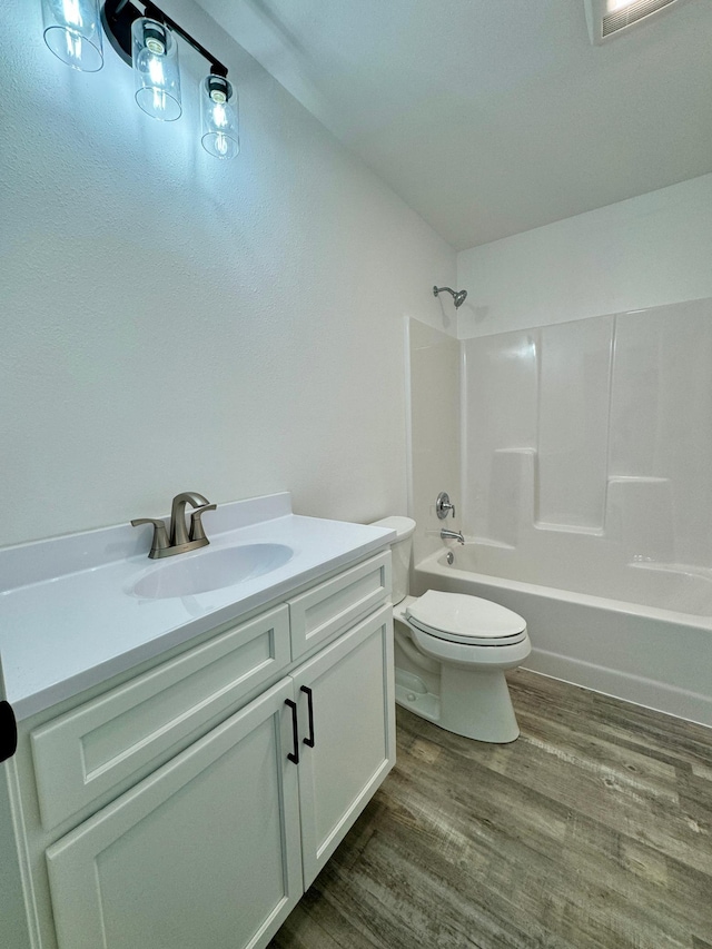 full bathroom with toilet, bathing tub / shower combination, wood finished floors, and vanity