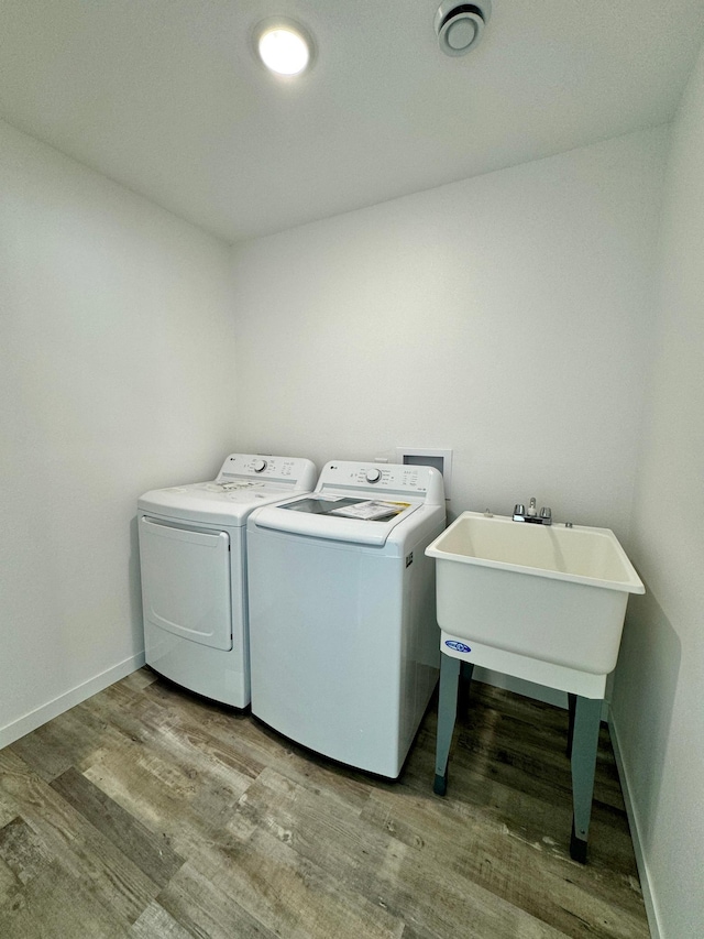 laundry area with wood finished floors, laundry area, baseboards, and separate washer and dryer