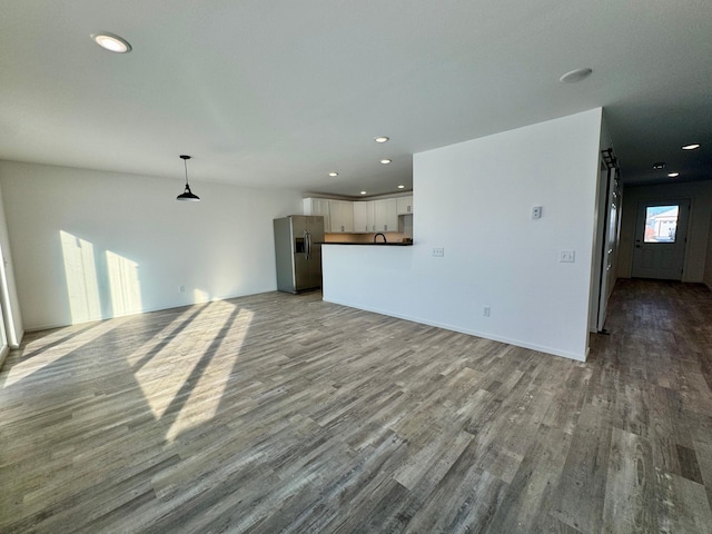 unfurnished living room featuring baseboards, wood finished floors, and recessed lighting