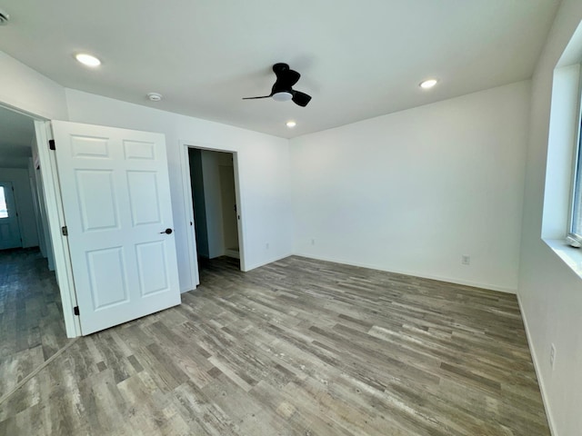 interior space featuring a ceiling fan, recessed lighting, baseboards, and wood finished floors