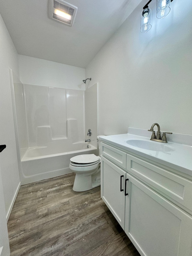 full bath with shower / bathtub combination, visible vents, toilet, vanity, and wood finished floors