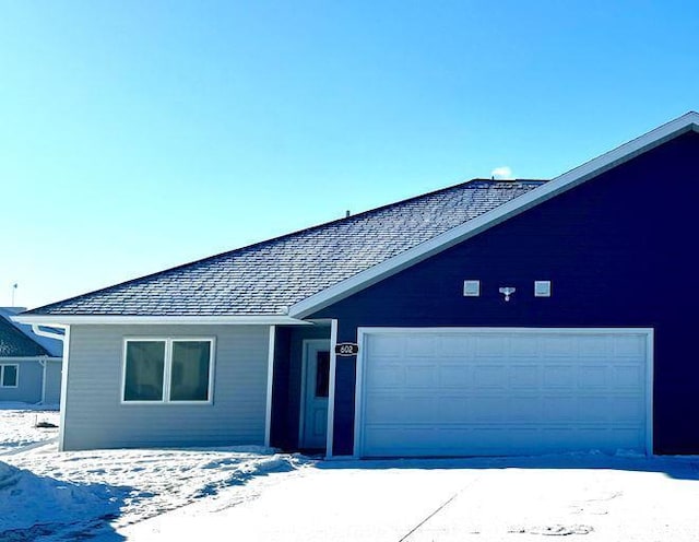 ranch-style house featuring a garage and a shingled roof