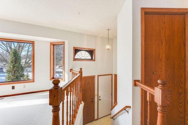 hallway featuring baseboards and an upstairs landing